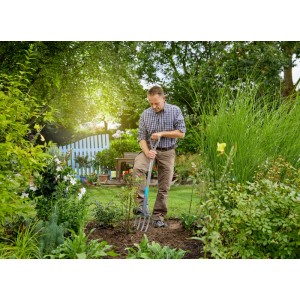 Homme utilisant une bêche-fourche Gardena NatureLine (117 cm) avec poignée en D dans le jardin pour creuser.