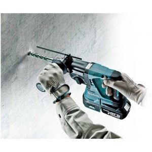 Marteau perforateur sans fil Makita DHR243ZJ perçant un mur.