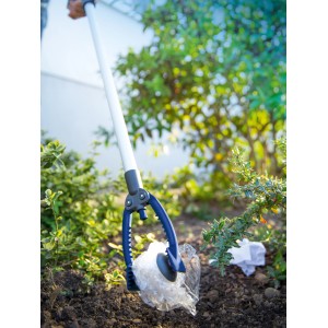 Pince de ramassage LUX (87 cm) ramassant des déchets dans le jardin.