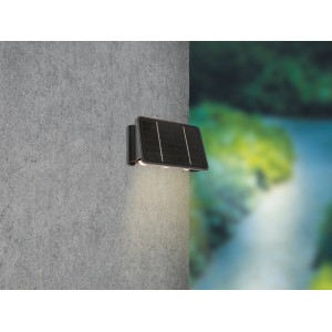 Lampada da parete solare a LED nera Cariati (17x11x6,5cm) su muro grigio. Lampada solare da esterno.