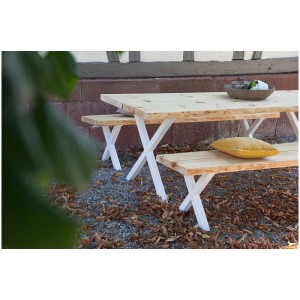 Table avec pieds en X blancs, assortie aux bancs.