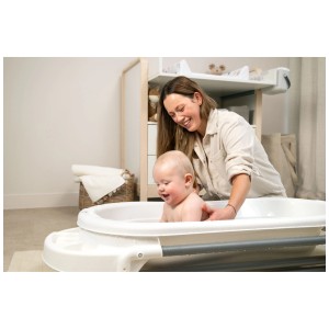 Station de bain Rotho Top Xtra blanche avec mère et bébé se baignant. Baignoire de douche avec rangements et porte-serviettes.