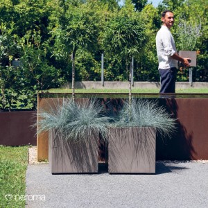 Zwei quadratische Quadro Millennium Pflanzkübel in Sandstone-Optik mit Gras im modernen Garten. Aus Kunststoff.