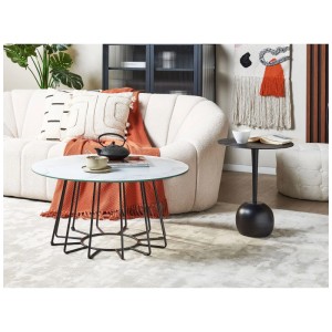 Table basse blanche Bernie effet marbre avec structure en métal noir dans le salon.