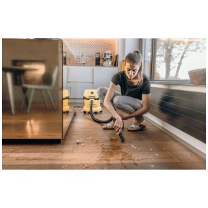 Femme utilisant l'aspirateur eau et poussière Kärcher WD 2 Plus pour nettoyer liquide et saleté sur parquet.