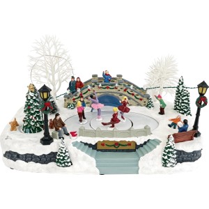 Village de Noël illuminé avec patinoire, figurines, pont, arbres et neige. Décoration hivernale de Noël.