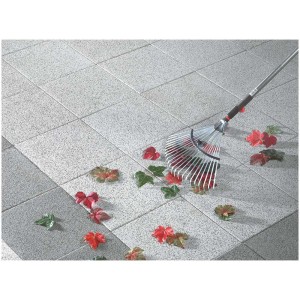 Piastrelle per esterni Mailand bianche 40x40 cm con foglie e rastrello su terrazza.