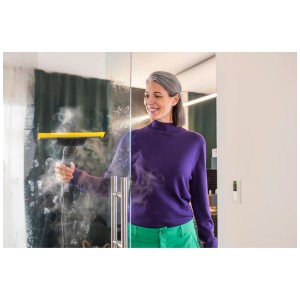 Femme nettoyant une fenêtre avec la buse pour fenêtre Kärcher Comfort et un nettoyeur vapeur.