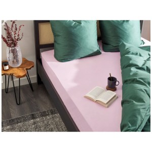 Lenzuolo con angoli Beliani Janbu, cotone, rosa pastello, 140x200 cm su letto con biancheria verde.