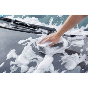 Anwendung von Sonax Xtreme Spray+Seal Autopflege mit Schwamm auf grauem Autolack.