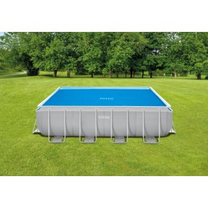 Piscine rectangulaire avec couverture solaire bleue Intex pour piscines Ultra Frame 488x244 cm dans le jardin.