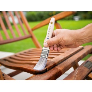 Mano che vernicia sedia in legno con pennello piatto LUX 30mm. Pennello per vernice con serbatoio per applicazione uniforme.