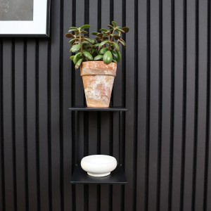 Mensola doppia nera Denpanels con pianta e decorazioni su parete a pannelli acustici.