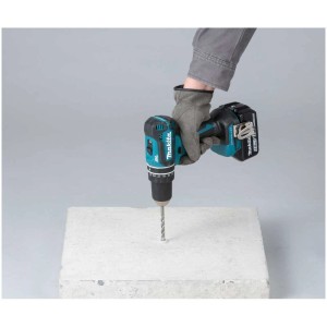 Trapano avvitatore a percussione a batteria Makita DHP485ZJ che fora il cemento.