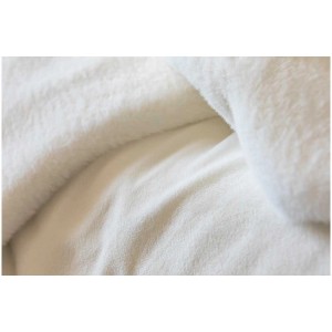 Primo piano della coperta bianca Coste (130x180 cm). Texture morbida, ideale come accessorio per la casa.