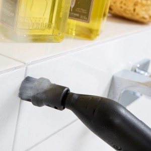 Nettoyeur vapeur Kärcher avec brosse ronde en cours d'utilisation pour nettoyer les joints de carrelage dans la salle de bain.