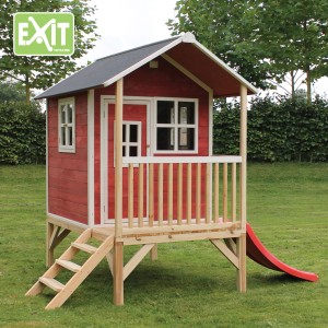 Cabane en bois rouge EXIT Loft 300 avec toboggan et escaliers dans le jardin.