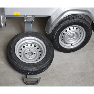Porta ruota di scorta Stema estensibile montato sotto un rimorchio auto con ruota di scorta.