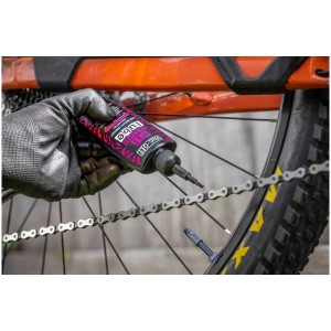 Applicazione di Muc-Off Kettenöl All Weather Lube su una catena di bicicletta.
