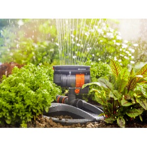 Arroseur oscillant Gardena Aqua Zoom Compact en action : arrosage des plantes dans le jardin.