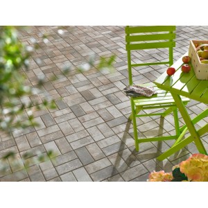 Pavés rectangulaires Jura-Nuanciert (20x10x6 cm) posés sur terrasse avec mobilier de jardin.