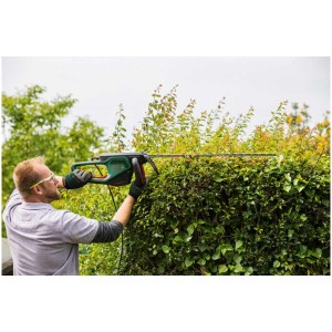 Uomo taglia la siepe con il tagliasiepi elettrico Bosch UniversalHedgeCut 65.