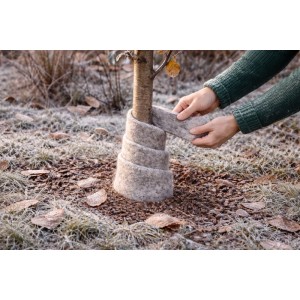 Hände wickeln graue Videx Garden Schafwoll-Wickelmatte um Baumstamm. Effektiver Frostschutz für Pflanzen im Winter.