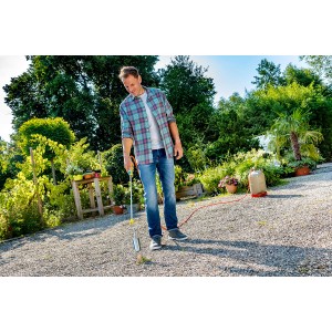 Uomo che utilizza il bruciatore per erbacce Gloria Thermoflamm bio Professional Plus con tubo in giardino.