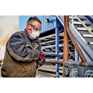 Embout dérouilleur à aiguilles Einhell en utilisation : un homme enlève la rouille du métal avec un burineur pneumatique.