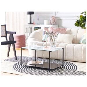 Table basse Gloster avec plateau en verre marbré blanc, cadre noir et étagère dans un salon moderne.