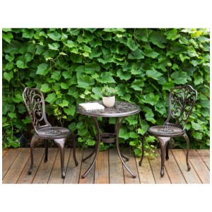 Set bistro Beliani TRIORA/ANDALO in alluminio marrone con tavolo e due sedie su sfondo verde.