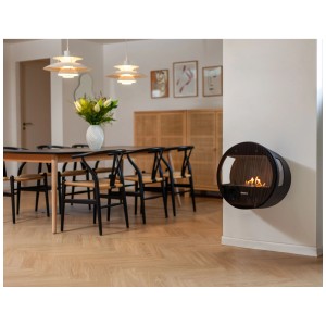 Cheminée bioéthanol Aduro B1, foyer décoratif rond noir fixé au mur dans le salon.