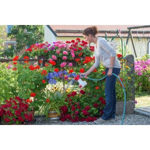 Femme fertilisant des fleurs avec le mélangeur d'engrais Birchmeier Aquamix 1.25 V. Pulvérisateur à pression pour engrais liquide.