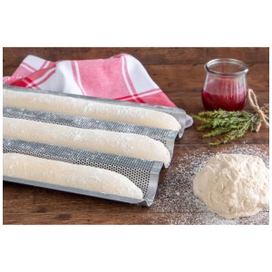 Silbernes Baguette Backblech aus Metall mit Teiglingen, Küchentuch und Teig auf Holz.