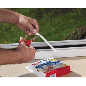 Coupe du joint de fenêtre en caoutchouc profilé en P Tesamoll blanc sur une fenêtre.