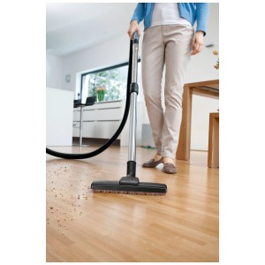 La bocchetta per parquet Kärcher nera pulisce un pavimento in legno.