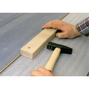 Kit de pose parquet/stratifié bois LUX Classic en utilisation avec marteau et martyr.