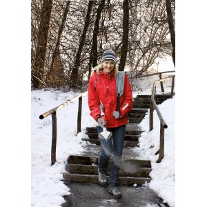 Femme répandant du sel sur des escaliers en hiver avec l'épandeur Birchmeier Granomax 5.