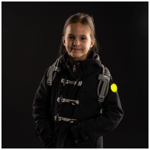 Kind mit Reer Sicherheitslicht Light&Go Grün am Rucksack für bessere Sichtbarkeit.