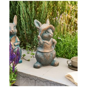 Beliani Gartenfigur Konakry: braunes Kaninchen mit Hut, rustikal patiniert, als Gartendekoration auf Steinmauer.