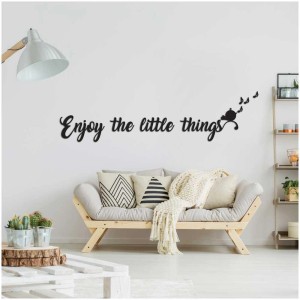 Sticker mural « Enjoy the little Things » en mousse 3D, taille L, sur un mur blanc au-dessus d'un canapé.