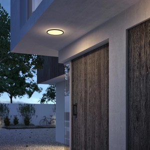 Plafonnier extérieur LED Philips SceneSwitch noir, 15W, avec lumière blanc chaud sur mur de maison.