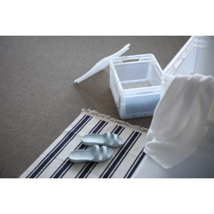 Contenitore Euro trasparente (20 l) con coperchio come scatola di immagazzinaggio, combinato con tessili da bagno e scarpe da bagno.