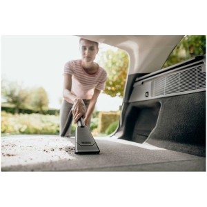 Femme aspirant le coffre avec la buse auto Kärcher. Accessoire pour aspirateurs eau et poussière.