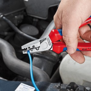 Pinza a crimpare Knipex per puntalini in uso, pinza con manico rosso-blu che crimpa il puntalino blu.