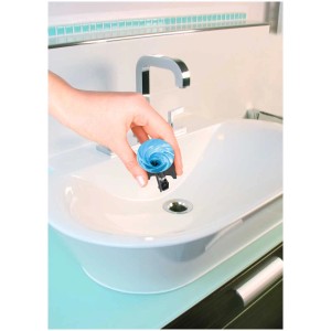 Mano che inserisce un tappo lavandino Pluggy Water blu in un lavandino.