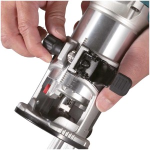 Gros plan : Affleureuse/défonceuse à une main Makita RT0702CX2J en cours de réglage.