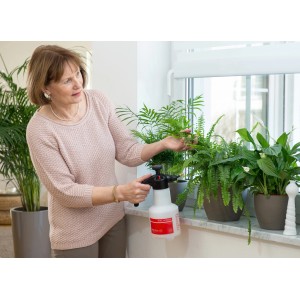 Femme utilisant un pulvérisateur à pression Birchmeier Super Star 1.25 sur des plantes d'intérieur.