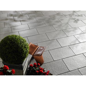 Pannelli per terrazza Kann Sincera grigi 60x40 cm posati con pianta e sedia sulla terrazza.