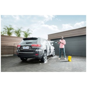 Uomo pulisce l'auto con Kärcher Ultra Foam Cleaner e idropulitrice. Detergente per veicoli.